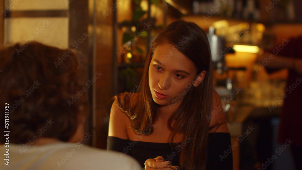 Girls sit at a table in a cafe, they eat and talk to each other Girls sit at a table in a cafe, they eat and talk to each other