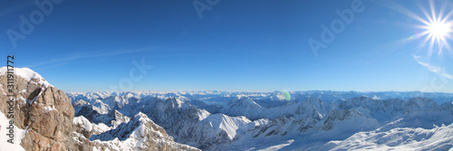A beautiful view over the german and austrian alps from the mountain  zugspitze  in a winter wonderland with blue sky