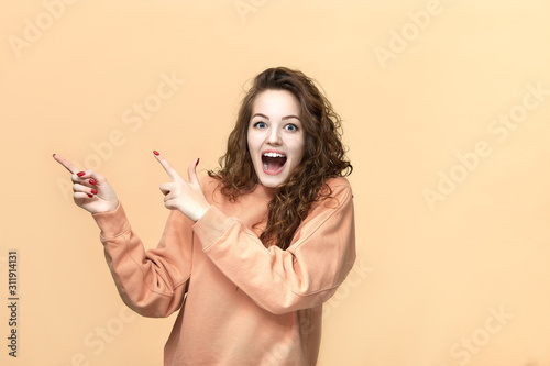 Obraz na plátně Portrait of a young beautiful woman wearing sweatshirt posing isolated over yell