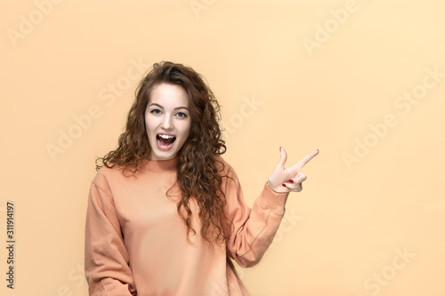 Portrait of a young beautiful woman wearing sweatshirt posing isolated over yellow background