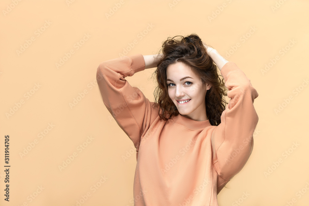Portrait of a young beautiful woman wearing sweatshirt posing isolated over yellow background Portrait of a young beautiful woman wearing sweatshirt posing isolated over yellow background