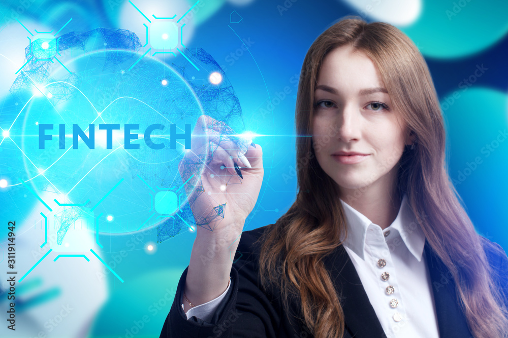 Business, Technology, Internet and network concept. Young businessman working on a virtual screen of the future and sees the inscription: Fintech Business, Technology, Internet and network concept. Young businessman working on a virtual screen of the future and sees the inscription: Fintech