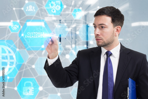 Business, Technology, Internet and network concept. Young businessman working on a virtual screen of the future and sees the inscription: Customer engagement
