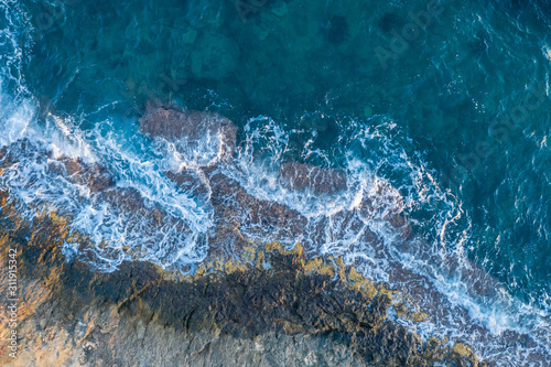 Waves beat against a rocky shore  aerial view