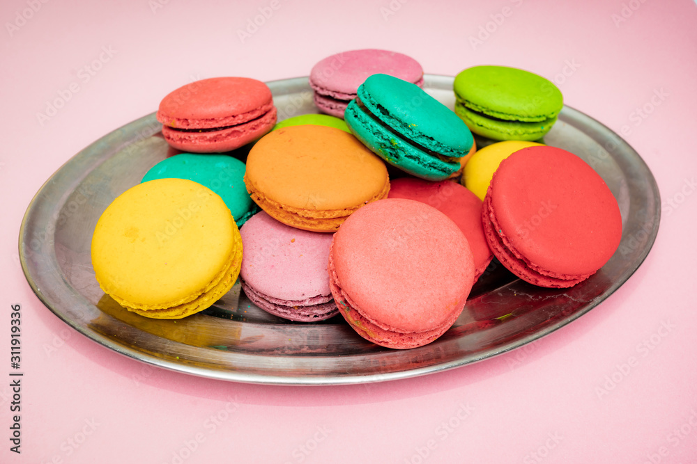 Naklejka premium A lot of french colorful macarons on a pink background