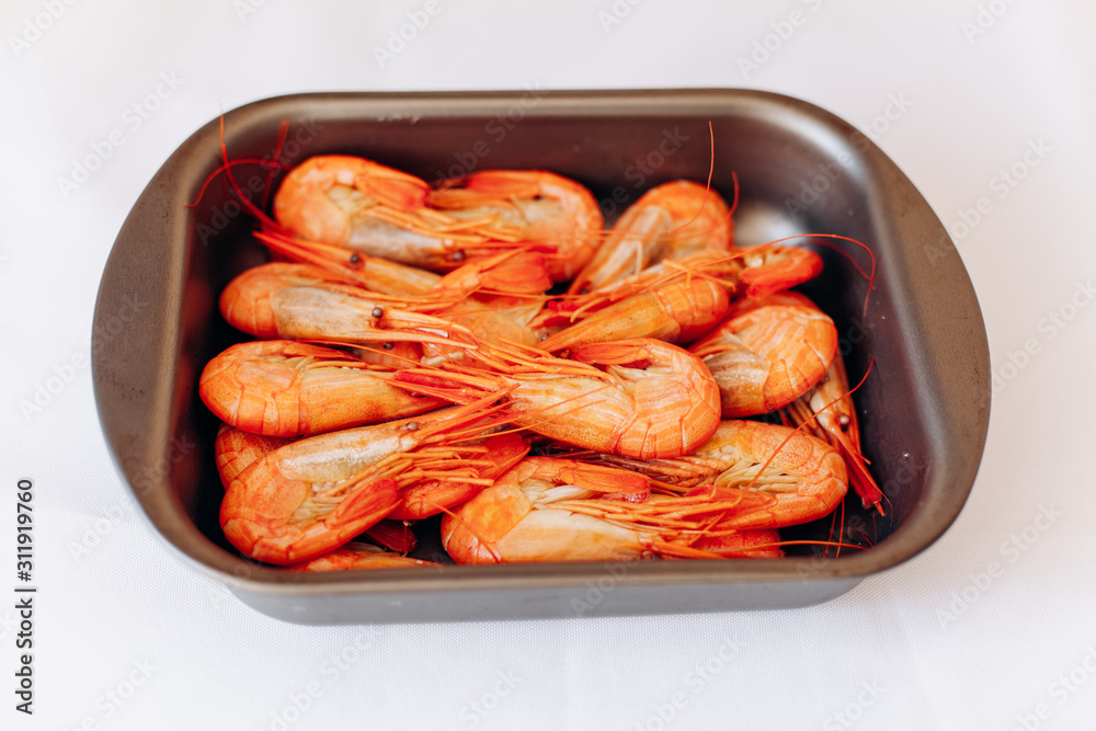 Bowl of fresh shrimp on white background