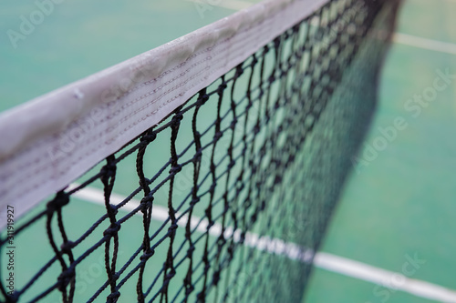 tennis net on a green tennis court