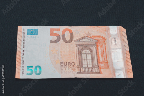 Fifty euro denominated paper money on a black background.