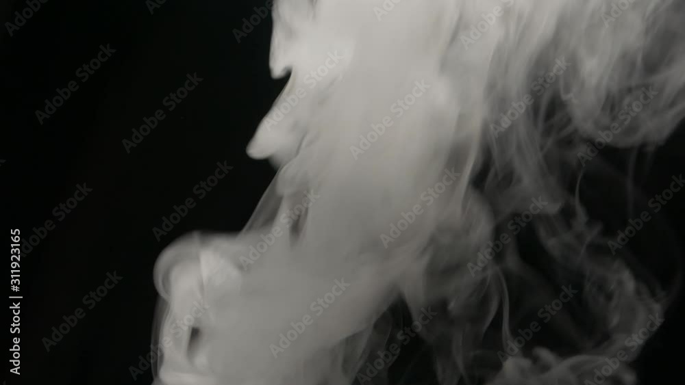 Smoking electronic cigarette. Closeup vapor floating in air on black background. Real dry smoke clouds fog overlay. Smoking electronic cigarette. Closeup vapor floating in air on black background. Real dry smoke clouds fog overlay.