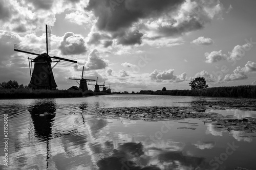  Landscape with windmills in Kinderdijk. Recreation area with 19 windmills.Travel in Netherlands.  Travel, sightseeing and tourism.  Photo in black and white.