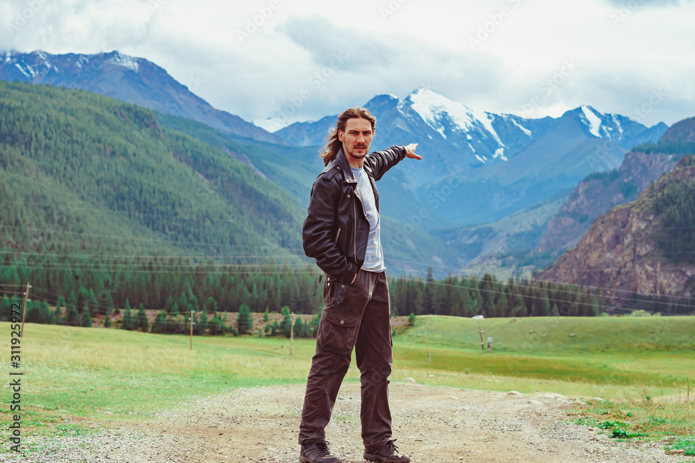 the guy stands against the background of snowy mountains the guy stands against the background of snowy mountains