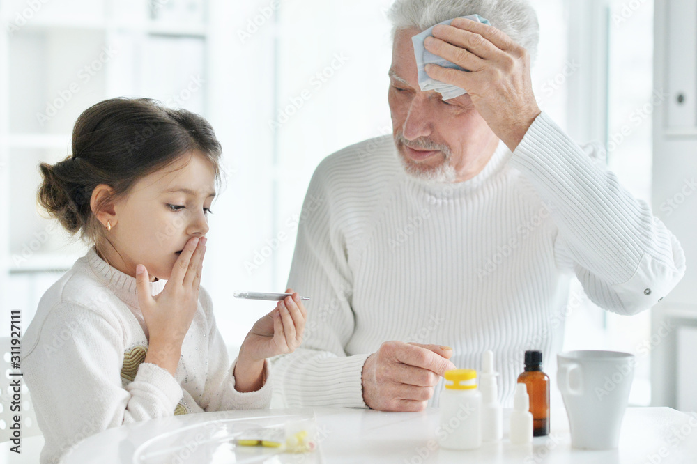 Sick granddaughter with grandfather sitting at home Sick granddaughter with grandfather sitting at home
