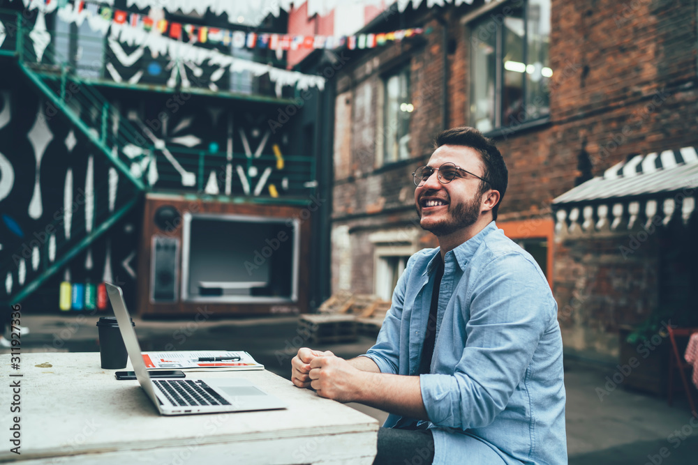 Excited freelancer using laptop in loft patio Excited freelancer using laptop in loft patio