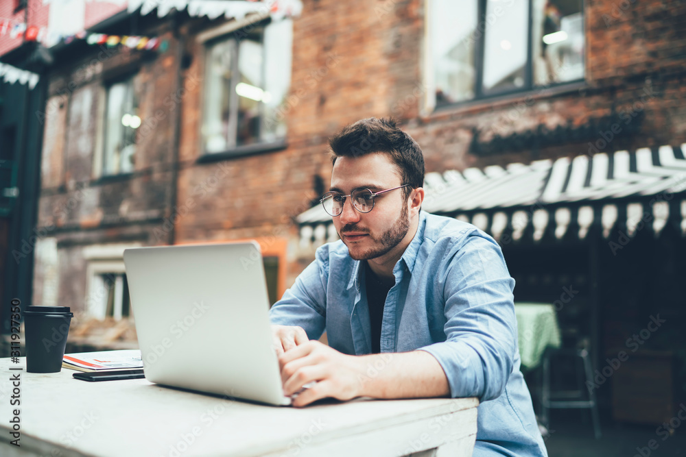 Focused remote worker browsing laptop at outside of house Focused remote worker browsing laptop at outside of house
