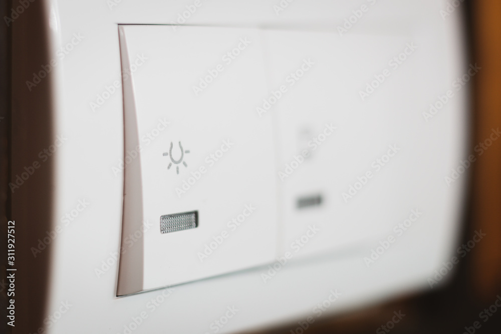 White light switch with icon on it, close up shot. White light switch with icon on it, close up shot.