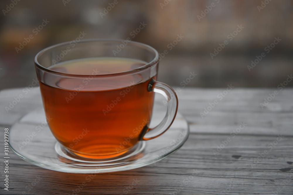 A cup of black tea on a wooden table