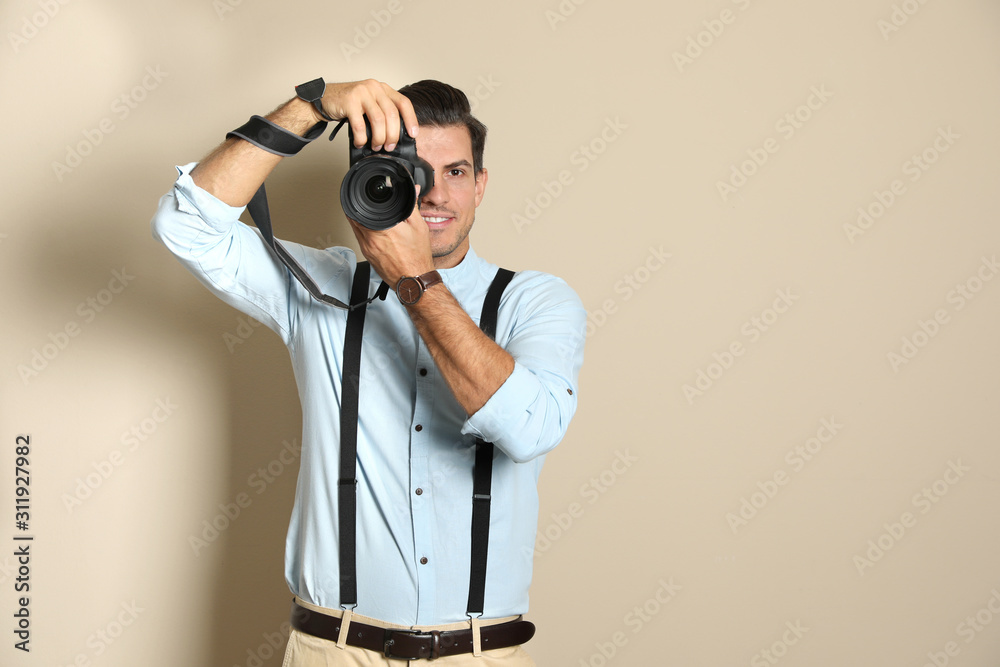 Professional photographer working on beige background in studio. Space for text Professional photographer working on beige background in studio. Space for text