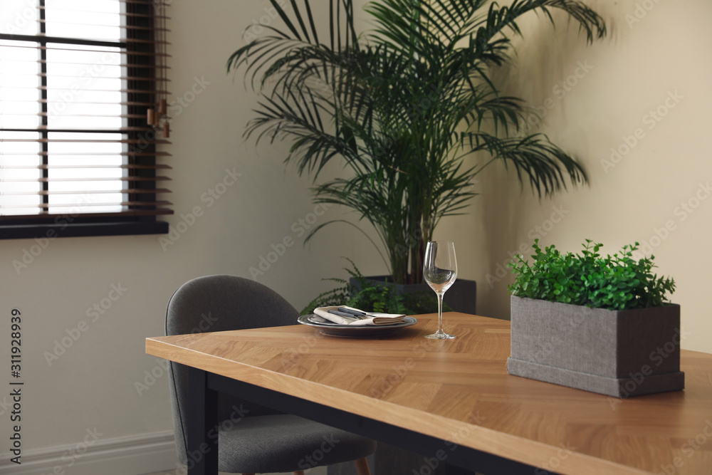 Dishware on wooden table in dining room. Stylish interior