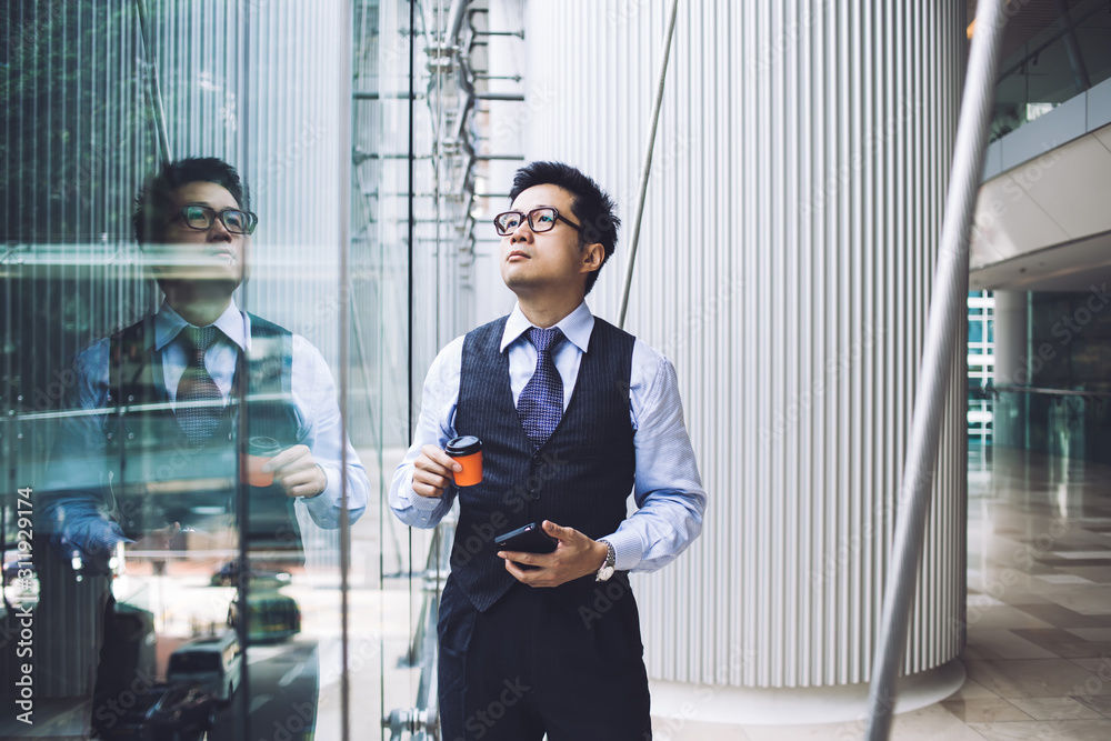Fototapeta premium Asian businessman standing in office building hall