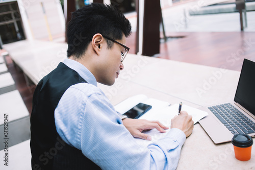 Young office worker making notes