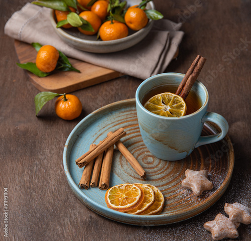 tea with tangerine and cinnamon with gingerbread on a wooden table