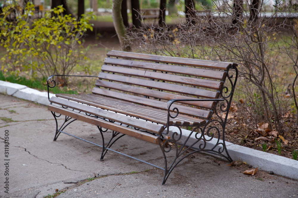 Blank Old bench in a shady area of the garden or the park,outdoor. Shaded wood park bench surrounded by greenery . Empty Park wooden bench Closeup view. Wood exterior material. Wood material details. Blank Old bench in a shady area of the garden or the park,outdoor. Shaded wood park bench surrounded by greenery . Empty Park wooden bench Closeup view. Wood exterior material. Wood material details.