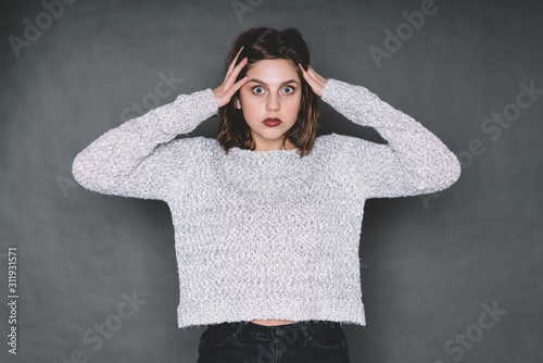 Shocked young woman perplexedly looking at camera photo