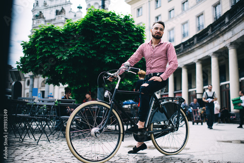 Hipster man on bicycle on street