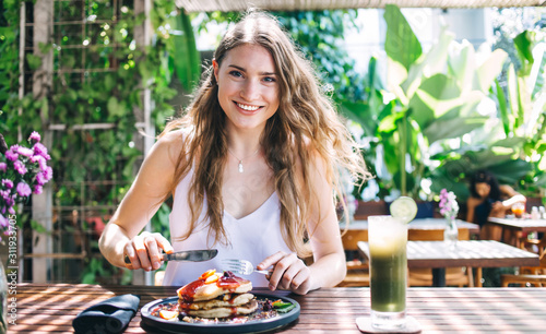 Content female having vitamin beverage and eating dessert in cafe