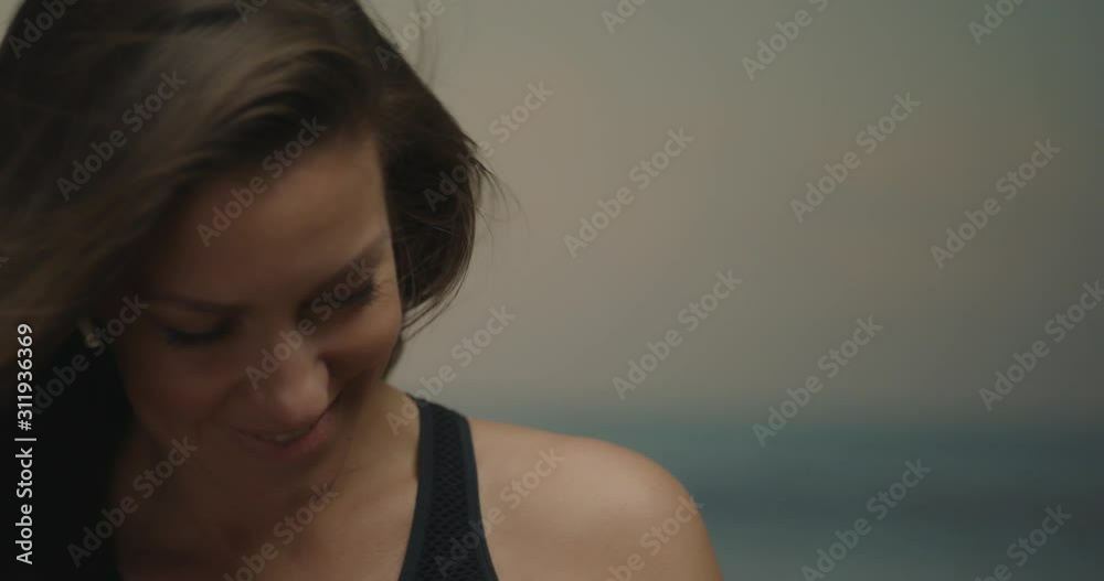 Portrait of a young woman dancing to music with headphones on a beach