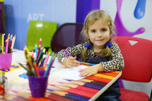 Portrait of a four year old toddler caucasian girl drawing. Education, arts and crafts