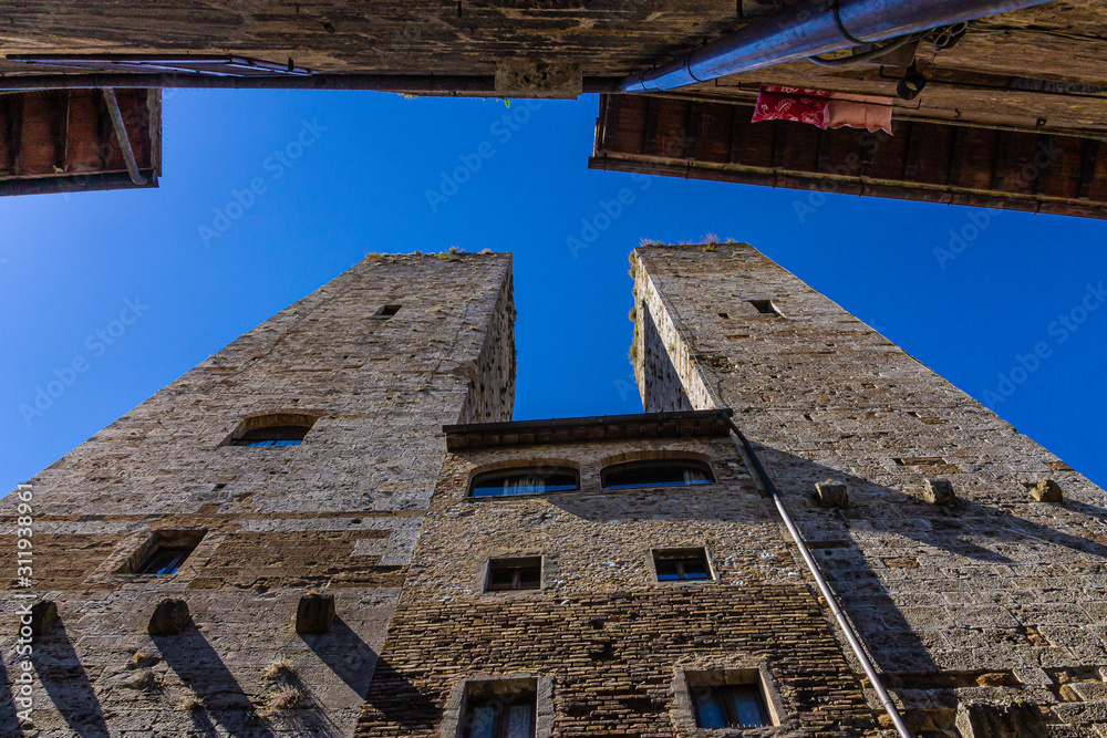 San Gimignano, Italy - 08.26.2017: Ancient millstones in a narrow alley in San Gimignano, Tuscany San Gimignano, Italy - 08.26.2017: Ancient millstones in a narrow alley in San Gimignano, Tuscany