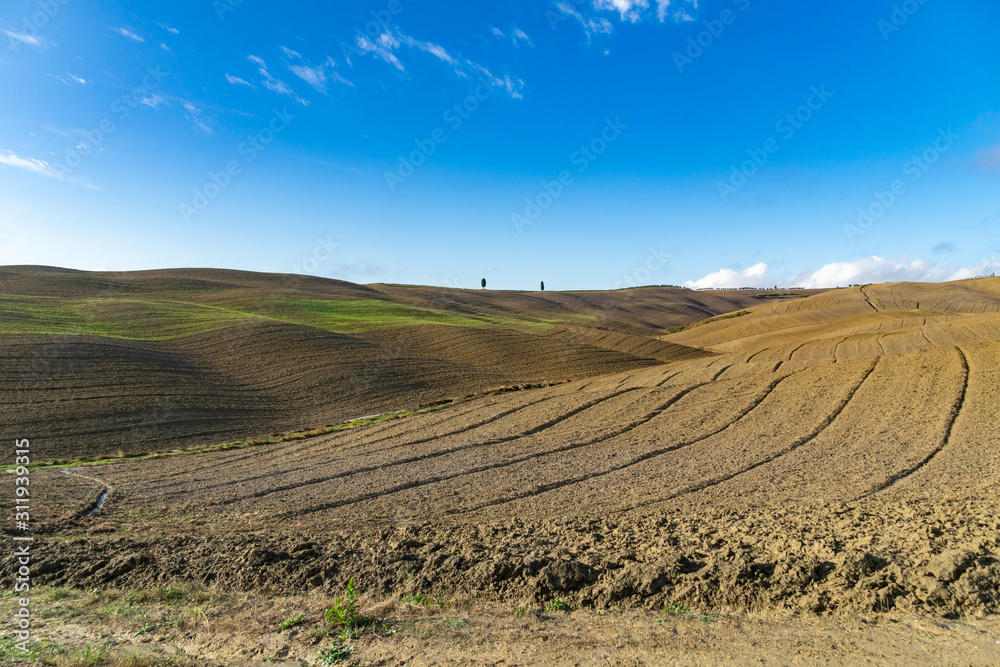 Wide view over the green rolling hills of the Tuscan