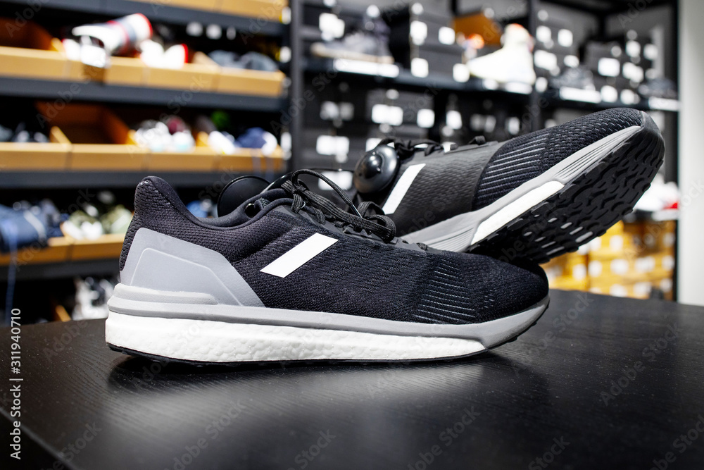 Pair sneakers on a store shelf. Shoe store. Close up view of sport footwear. Retail shop in mall. Pair sneakers on a store shelf. Shoe store. Close up view of sport footwear. Retail shop in mall.
