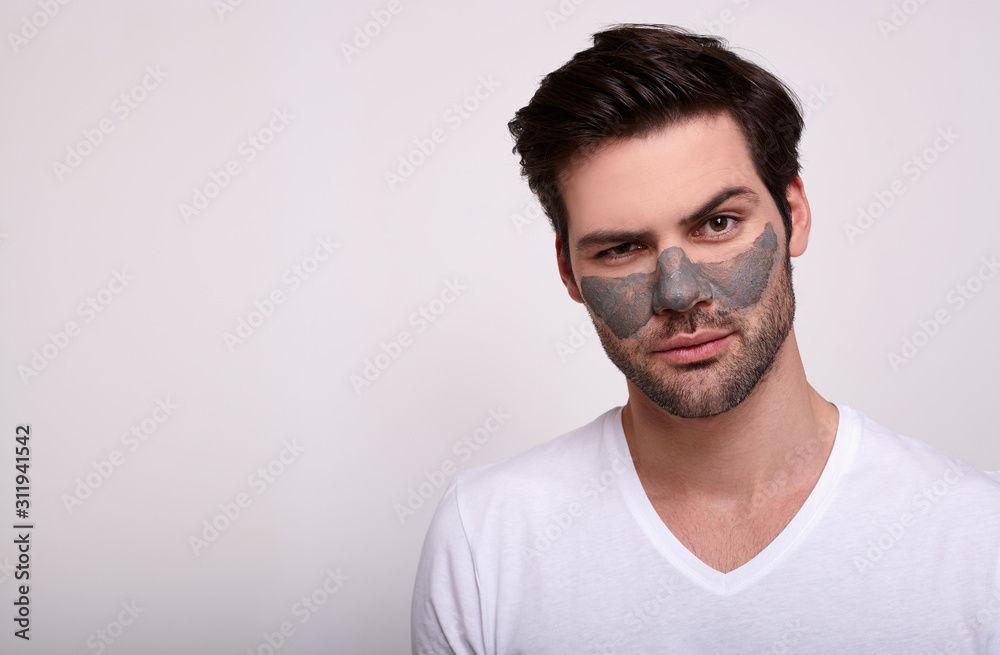 Portrait of a handsome guy in a white t-shirt in a cosmetic face mask. Portrait of a handsome guy in a white t-shirt in a cosmetic face mask.