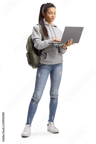 Female student standing and typing on a laptop photo