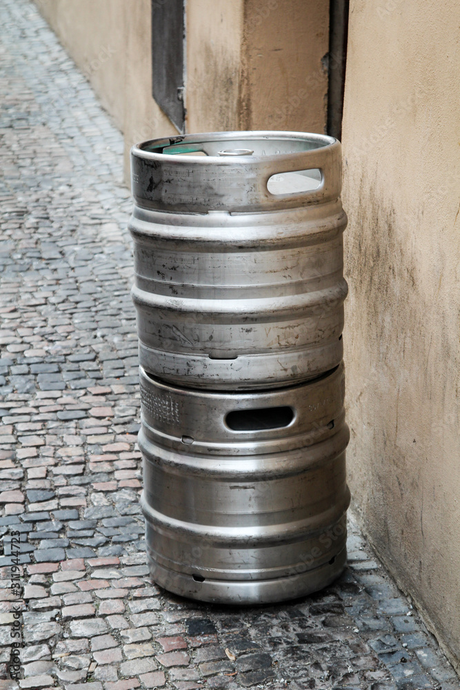 zwei Metallfässer für den Biertransport stehen auf dem Fußweg zwei Metallfässer für den Biertransport stehen auf dem Fußweg