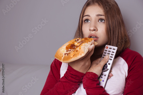 Teenage girl eating pizza w...