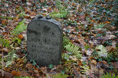 Steine auf einem kleinen, verwitterten, jüdischen Grabstein (Berlin-Weißensee) photo