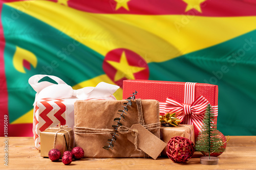 Grenada new year celebration theme. Wrapped christmas gifts on waving national flag background. Merry christmas concept.