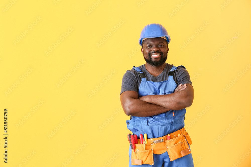 African-American electrician on color background African-American electrician on color background