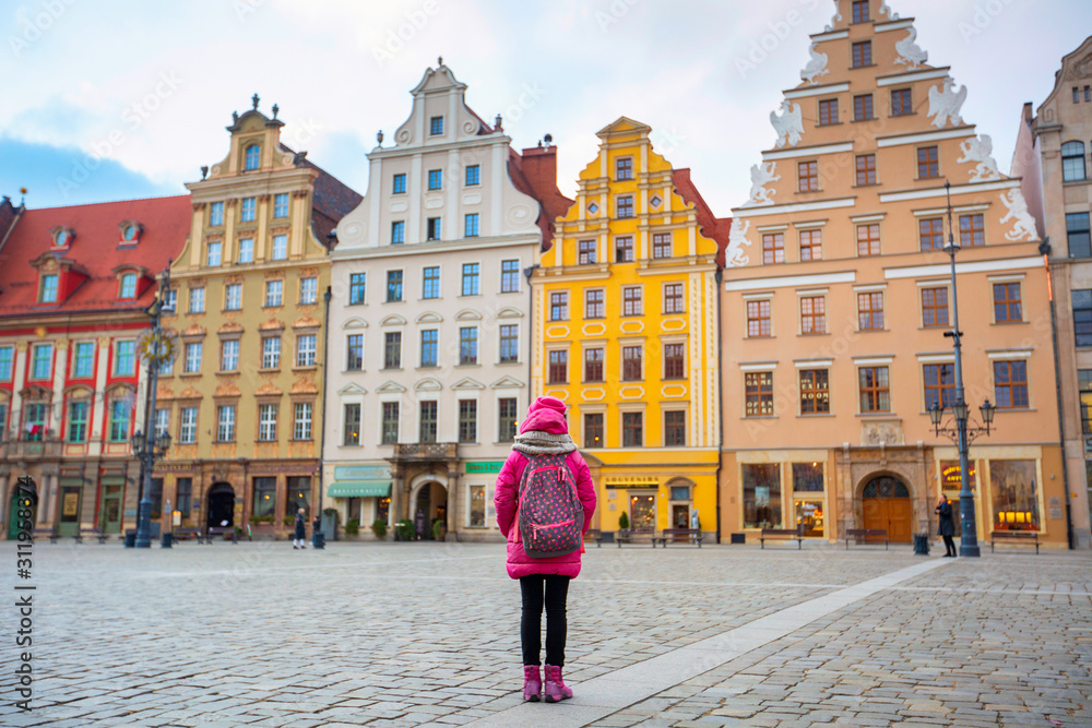 Portrait happy winter mood of joyful young girl in pink jacket and hat having fun on square in trip on holidays . Positivity, joy, happiness, tourism, travel, vacation