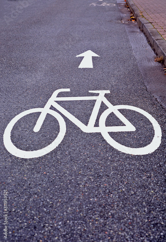 White sign showing a bike symbol on a street