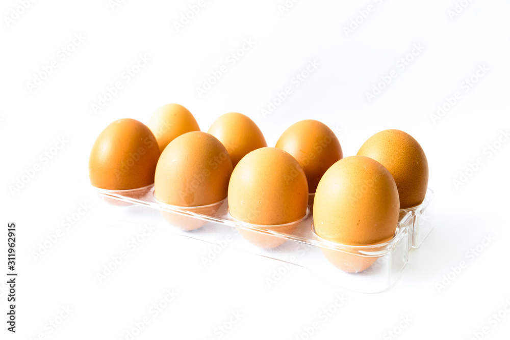 Studio shot eight raw brown eggs on plastic package isolated on white Studio shot eight raw brown eggs on plastic package isolated on white