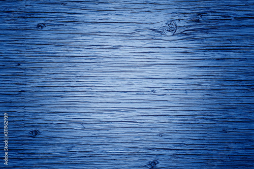 Wooden board planks pattern with lines, curves. Rough surface with copyspace for text. Toned with classic blue 2020 colour. Natural eco environmental background texture.