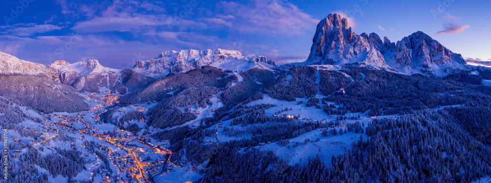 Fototapeta Piękny panoramiczny widok na góry Dolomity o zmierzchu w okresie zimowym. Magiczny zimowy górski fioletowy zachód słońca z górskiej miejscowości narciarskiej. Czas świąt.
