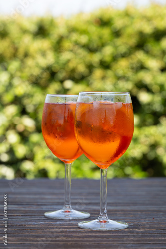 Aperol spritz drink in a wineglass. Ice and slice of orange