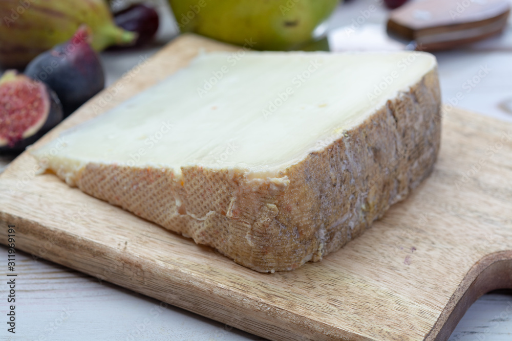 Piece of French cheese Tomme de Brebis made from sheep milk served as dessert with fresh figs and pears Piece of French cheese Tomme de Brebis made from sheep milk served as dessert with fresh figs and pears