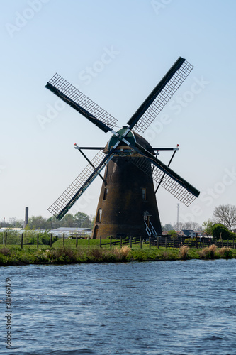 Traditional Dutch wind mill built along the canal in North Holland  spring landscape