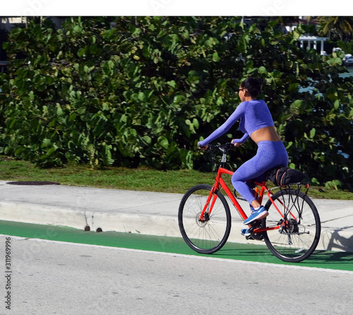Attractive afro American woman riding a bicycle on the Venetia Causeway near Miami Beach,Forida